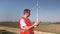 Technician uses tablet looking at wind turbine towers