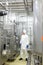 technician in white coveralls and cap controlling industrial process in plant