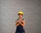 Technician woman ware yellow helmet with grey T-shirt and denim jeans apron dress standing and thumbs up two hands.