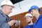 Technician worker showing apprentices to install video-surveillance-camera on wall