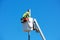 Technician works on installing or repairing a small cell antenna on a lamp post from the platform of the telescopic boom lift.