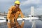 Technician Young Wearing Safety Protective Clothing while Installing Solar Panel or Photovoltaic in Daytime on Factory Roof