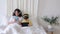 Technology addicted family of mum and kid in bed use smartphone and digital tablet wear headphones