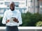 Technology makes connected easier. a young businessman using a tablet against an urban background.