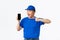 Technology, online shopping and shipping concept. Cheerful smiling asian courier in blue uniform, pointing finger at