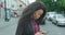 Technology and People. Mobile dependence. Attractive young african girl is crossing the road and texting, browsing via