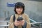 Technology and people. Young asian girl, student standing on street in headphones, listens music and smiling, chats on