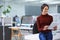 Technology that simplifies business. Shot of a happy young businesswoman using her tablet while standing in the office.