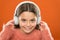 The technology uses focused sound waves. Small child wearing wireless stereo headphones. Technology and music. Stereo