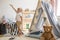 Teddy bear on the floor of stylish single child playroom with tent and toys, real photo