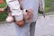 A teddy bear in the hand of a man. old person walk on the street. Grandpa holds a toy of a grandson or granddaughter`s child