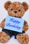 Teddy bear holding blue sign saying Happy Birthday
