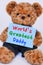 Teddy bear holding blue sign saying World`s Greatest Dad