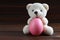 Teddy Bear holding an Easter egg, chicken, wood background