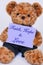 Teddy bear holding a purple sign that says Faith, Hope and Love