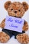 Teddy bear holding a purple sign that says Get Well Soon