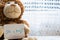 Teddy bear holds an announcement card for baby boy, space for text