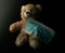 Teddy bear with a medical mask in darkness. Chilhood preventing covid-19.