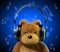 Teddy bear with music headphones. Blue background with musical notes.