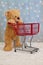 Teddy bear pushing red shopping cart