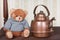 Teddy bear on the shelf with retro kettle still life