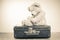 Teddy Bear toy alone on suit case. Vintage style sepia photo