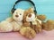Teddy bear toy headphones listening on wooden background