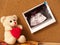 Teddy bear with an ultrasound photo pinned on cork
