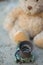 Teddy bear with a white ribbon thrown into the street in the fall in the rain