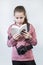 Teen age girl reading service manual book for dlsr camera, beginner in learning photography, a grey background