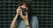 Teen Age Girl Taking Photo By Vintage Film Camera In Front Of Metal Fence