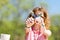 Teen aged girl in red checkered shirt sitting by table on garden party - crossing forks