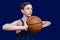 Teen basketball player in a sleeveless t-shirt holds the ball in his hands. Template for the design of a sports poster or news