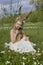 Teen beautiful blonde girl wearing white dress with deer horns o