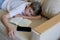 Teen blonde boy sleeping with an open book and a phone.