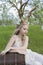 Teen blonde girl wearing white dress with deer horns on her head