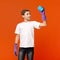 Teen boy cleaning transparent glass wall with sponge