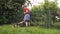 Teen boy cutting grass with electric lawn mower