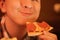 Teen boy eats pizza and enjoys it, closeup enjoying and savoring.