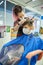 Teen boy in face mask doing haircut at barber shop