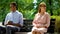 Teen boy and girl ignoring each other sitting on bench in park, failed date