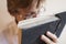 Teen boy in glasses reads a book