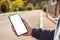 A teen boy holds a smartphone in his hand. Blurred empty street on the background. Close up. Mock up. The concept of communication