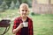 Teen boy kid in checkered shirt holding a cup of drink. Travel, hike, vacation, camping concept.