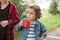 Teen boy kid and little girl holding a cups of drink. Travel, hike, vacation, camping concept.