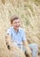 Teen boy kid in wheat field in a summer day