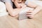 Teen boy lies on floor and watches video in smartphone. Selective focus on smartphone