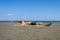 Teen boy lies on yellow towel and sunbathes on the beach.