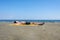 Teen boy lies on yellow towel and sunbathes on the beach.