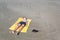 Teen boy lies on yellow towel and sunbathes on the beach.